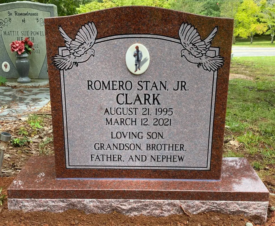 A red granite upright with doves and a portrait