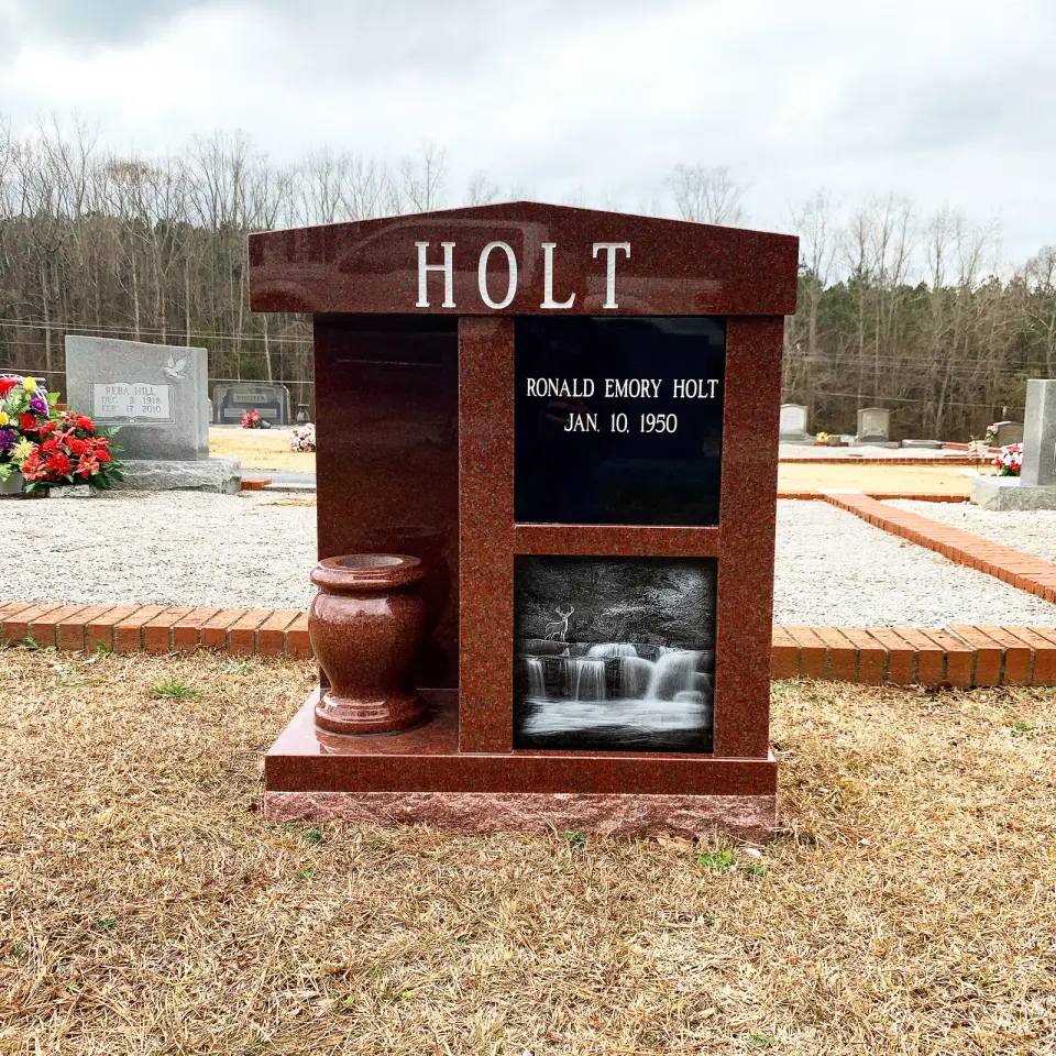 A red granite cremation memorial with niches, a vase and an etched picture