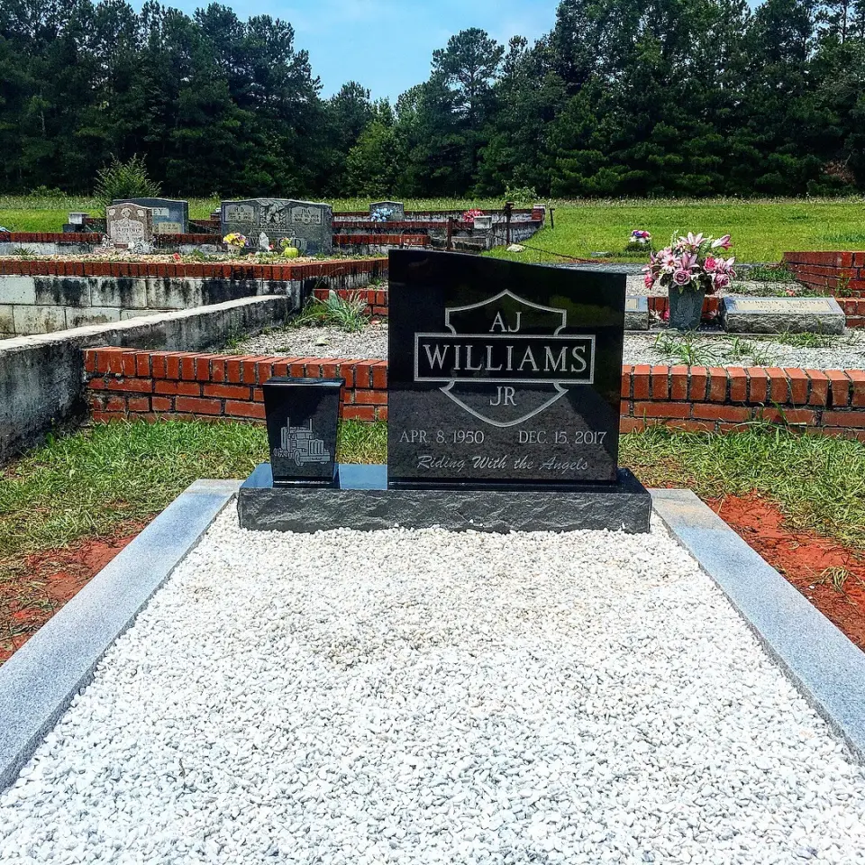 A black granite upright with a granite ledger and gravel bed