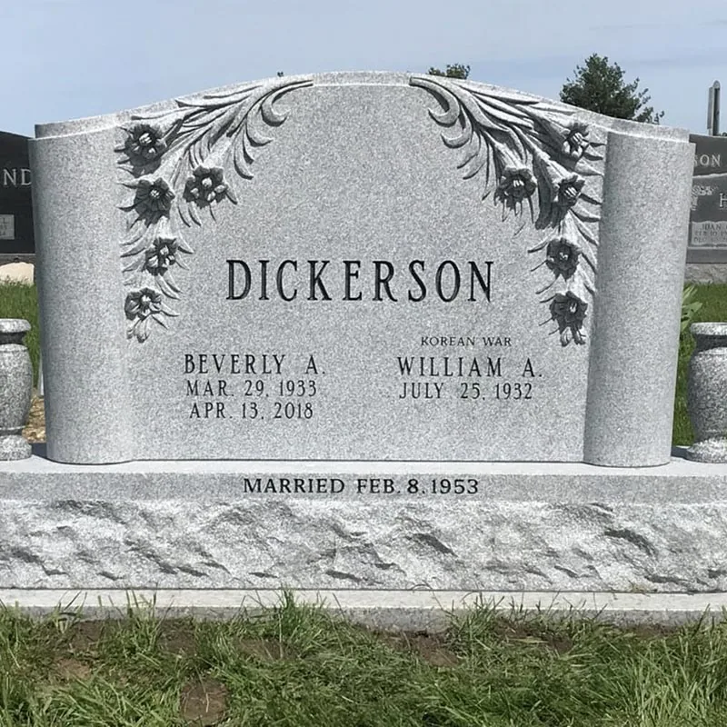 Light gray granite companion headstone with carved flowers and a scroll
