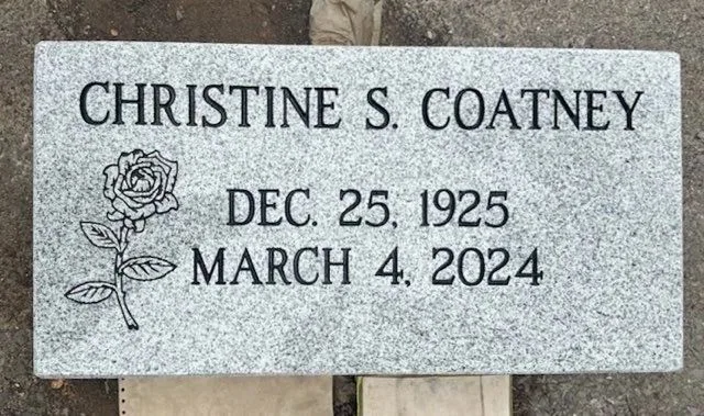 Gray granite flat marker with a carved rose, Christine S. Coatney