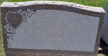 Rose granite slant marker with a carved heart and flowers